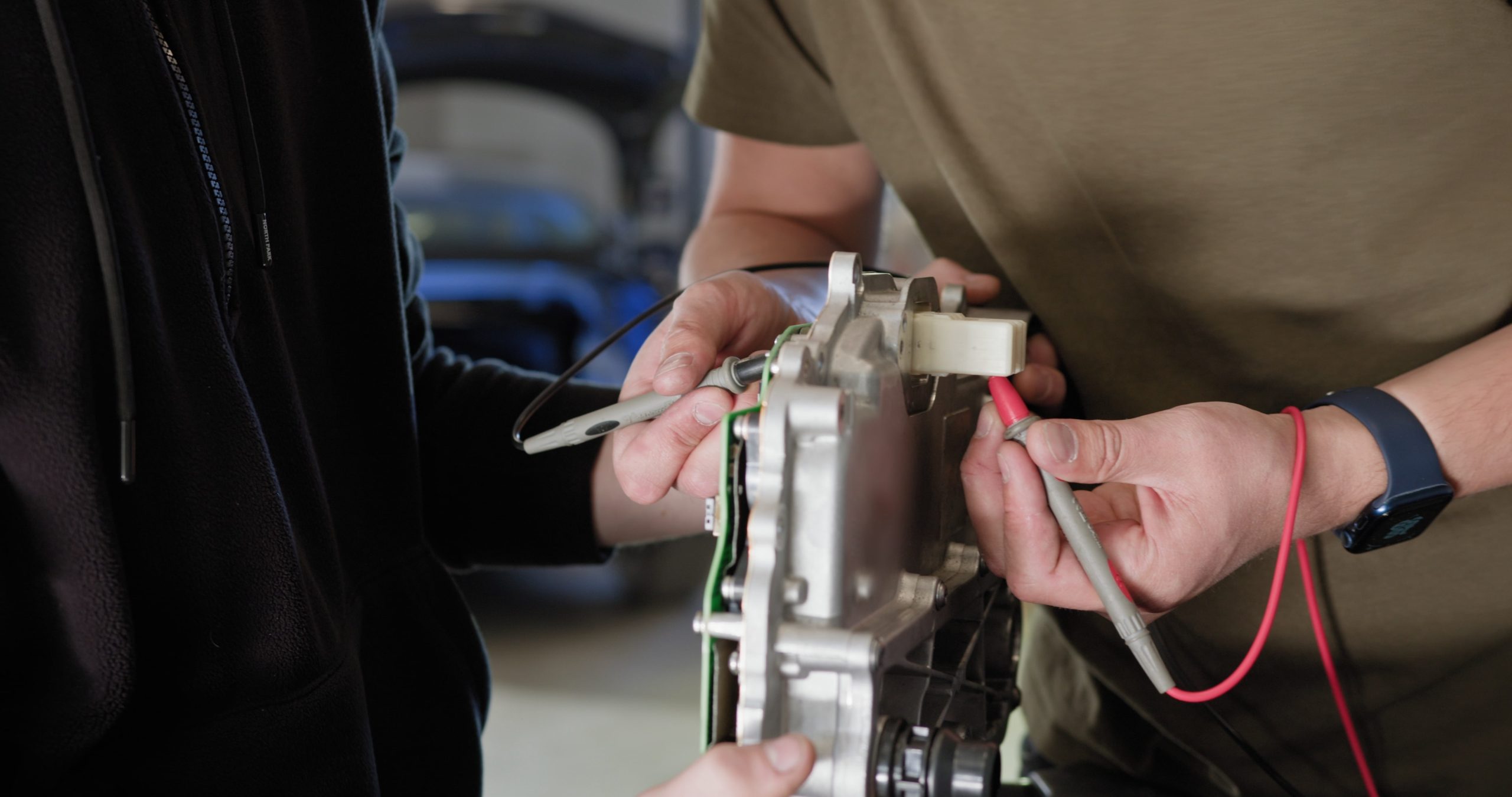 Checking electric car engine for repairs and making sure electric car charger is fine for driving