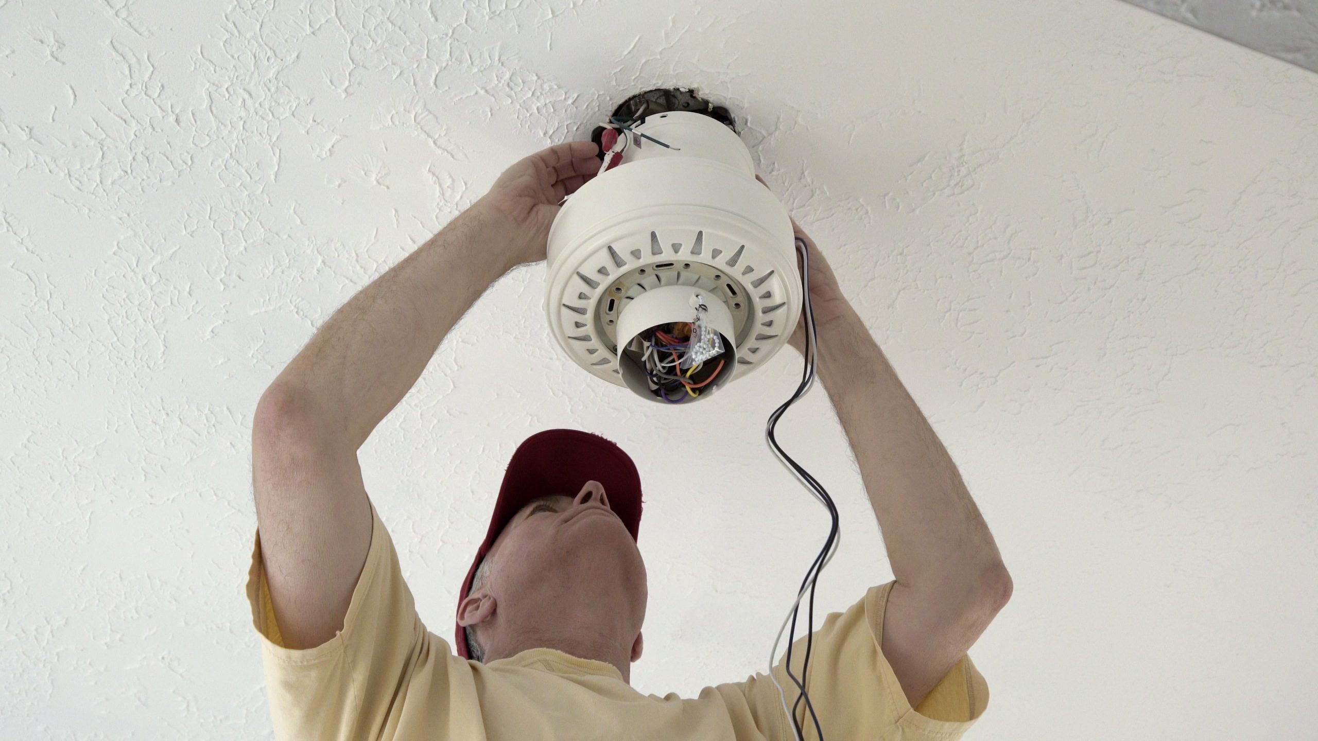 Electrician checking on ceiling fan installation