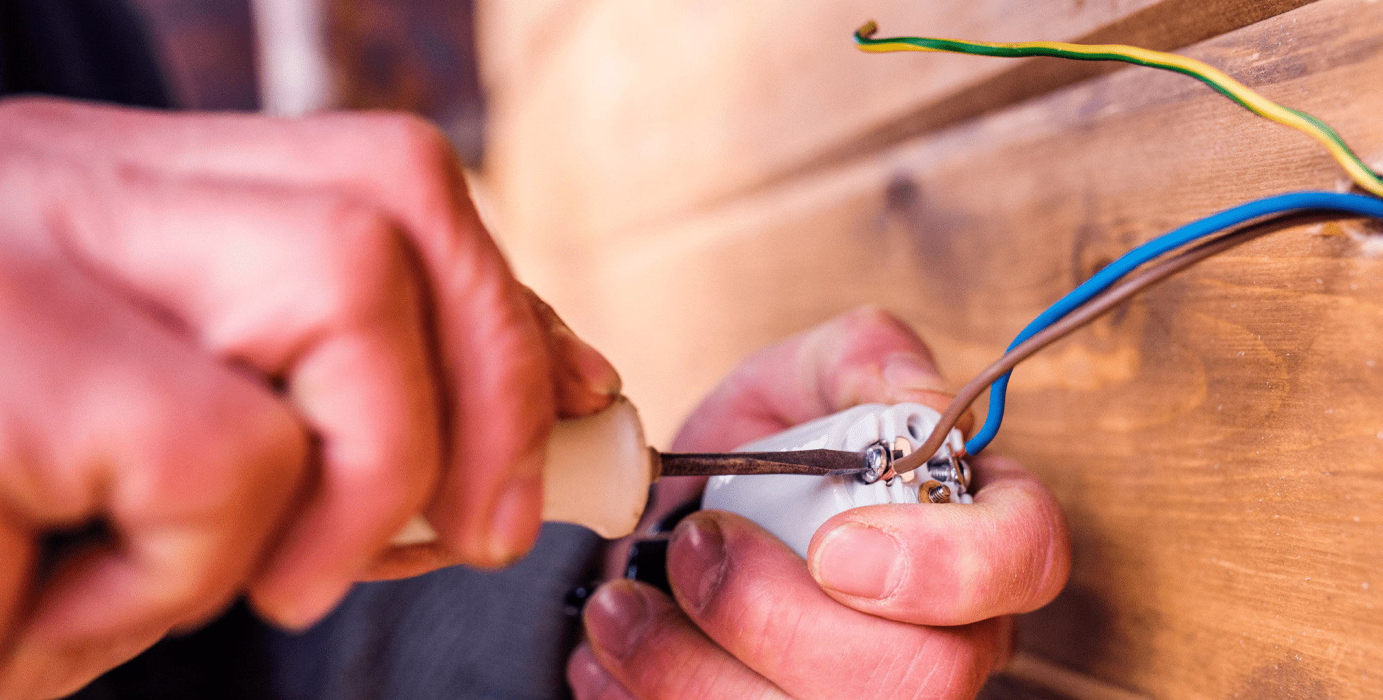 Electrician working with wiring with screwdriver into wires